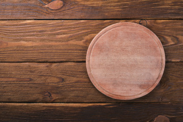 Fototapeta na wymiar Kitchen wooden board. On a wooden background. Top view. Free space for your text.