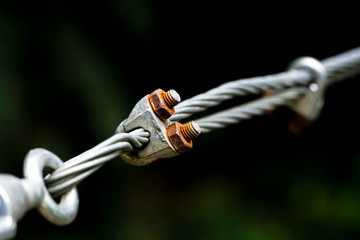 A close up of heavy duty steel wire cable connector. Coils of wire rope or cable used for...