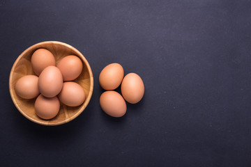 Fresh Eggs in bowl on black stone table background. Free space for text and design