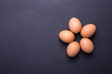 Fresh Eggs in bowl on black stone table background. Free space for text and design
