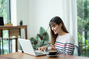 asia woman online shopping using credit card with laptop computer on wood table at cafe restaurant,Digital lifestyle concept.