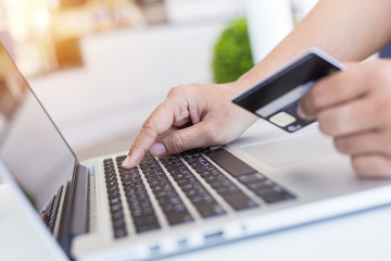 Fototapeta na wymiar Woman hands holding credit card in front of laptop on the desk. Easy way online shopping concept