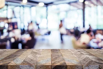 Foto op Plexiglas Restaurant Lege rustieke oude houten tafel en wazig mensen dineren in restaurant met bokeh lichte achtergrond. productweergavesjabloon. Zakelijke presentatie.