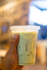 Ice green tea with milk in plastic glass