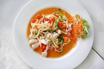 Stir fried squid with salted egg yolk in white plate on wood table.