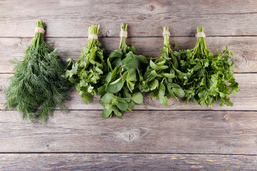 Different fresh herbs on grey wooden table