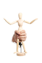 Male hand with wooden figure punching through the paper
