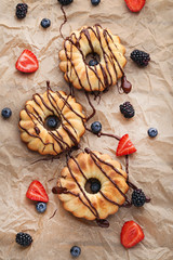 Delicious bundt cakes with berries on brown background