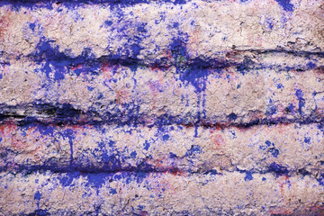 Background and wallpaper or texture of a pink wooden board with blue paint stains.