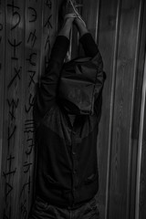 A man with his hands tied hanging from the ceiling.