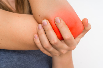 Woman with elbow pain is holding her aching arm