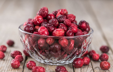 Some fresh Dried Cranberries on wooden background (selective focus; close-up shot)