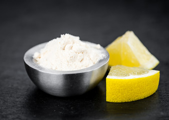 Fresh made Lemon powder on a slate slab (close-up shot; selective focus)
