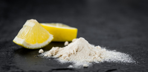 Fresh made Lemon powder on a slate slab (close-up shot; selective focus)