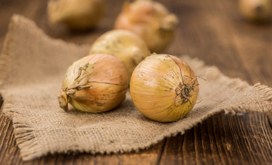 Wooden table with White Onions, selective focus