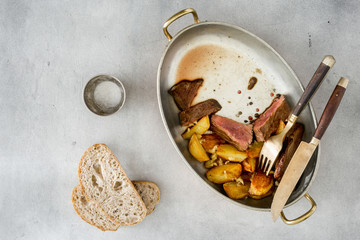 Slices of beef steak with potatoes in garlic sauce