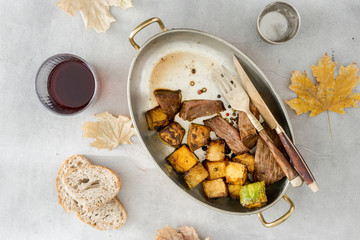 Beef steak with roasted pumpkin in pan with red wine