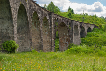 Fototapeta na wymiar The old Austrian stone railway bridge viaduct in Ukraine