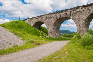 The old Austrian stone railway bridge viaduct in Vorokhta and bicycle near it