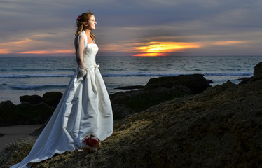 Fototapeta na wymiar Novia recién casada enm la playa de noche.