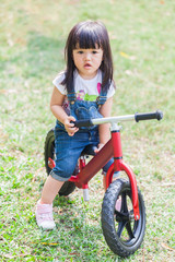 Cute Baby Girl 2-3 Year Old Riding the Strider in the Garden