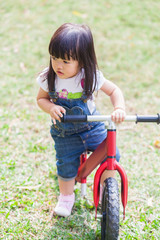 Cute Baby Girl 2-3 Year Old Riding the Strider in the Garden