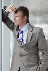 A man in a business suit looks out the window