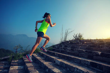 fitness woman trail runner running on the top of sunrise mountain