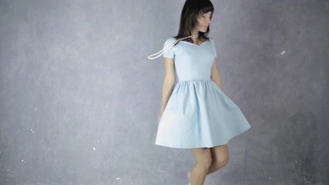 lonely young attractive woman in blue dress laughs and dances