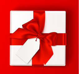 Realistic white gift box with red bow and empty sale tag isolated on red background. Holiday decorations. Vector present