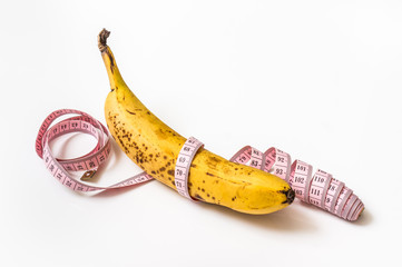 Yellow banana with measuring tape - diet concept