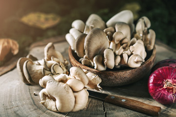 Raw mushrooms on the stump and autumn leaves. Autumn still-life. Selective focus. Autumn background.