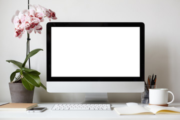 Picture of modern personal computer with blank white copy space screen resting on desk with...