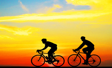 Obraz premium Silhouette man and bike relaxing on blurry sunrise background