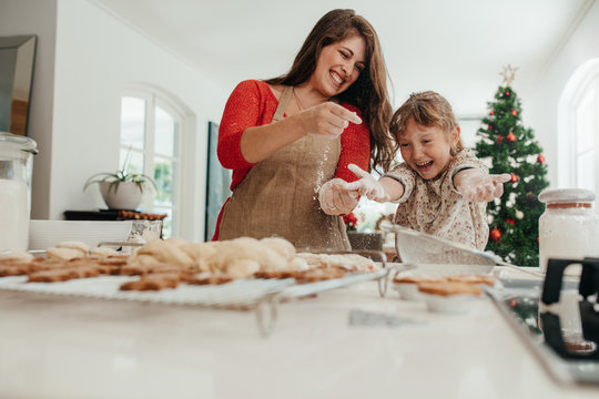 Mother and daughter having fun while making Christmas cookies.