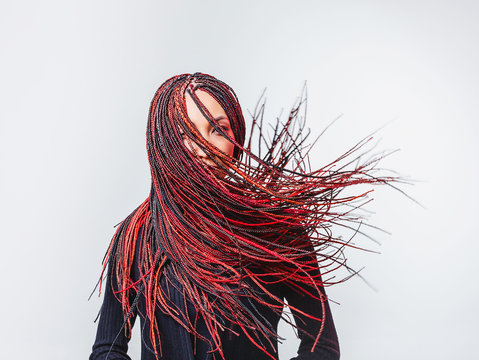 Conceptual studio shot of a modern creative woman with colorful flying braided dreads