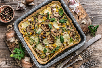 Homemade mushrooms pie on a wooden background.