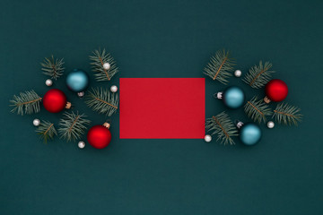 Red card and Christmas decoration on shaded spruce background