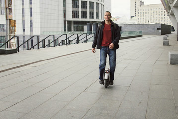 Casual man riding on one wheel electronic monocycle in the city. © ninelutsk
