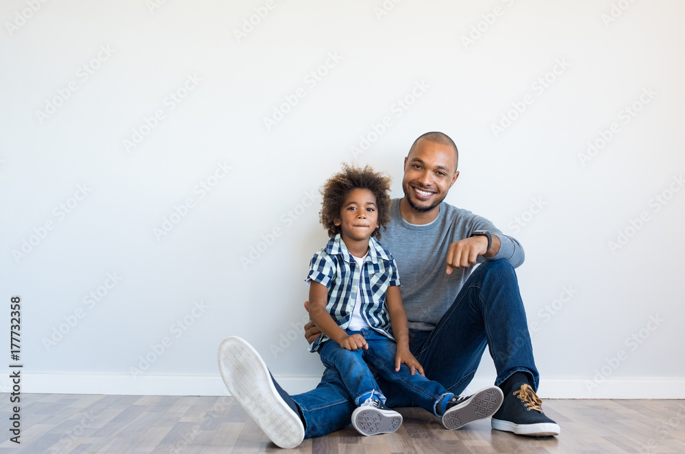 Wall mural Happy father and son sitting