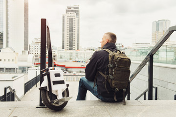 Casual man riding on one wheel electronic monocycle in the city. © ninelutsk