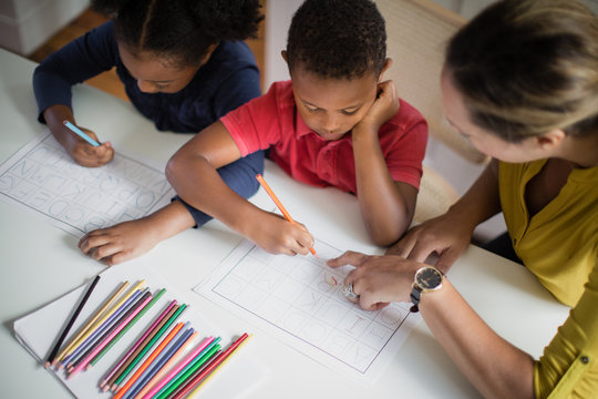 Mother teaching children to write