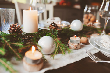 Festive Christmas and New Year table setting in scandinavian style with rustic handmade details in...