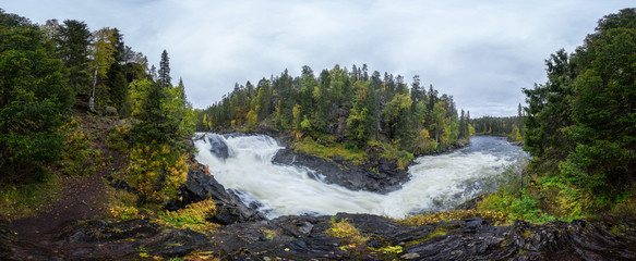 Cliff, stone wall, forest, waterfall and wild river panoramic view in autumn. Fall colors - ruska time in Myllykoski. Karhunkierros Trail, Oulanka National Park in north Finland. Lapland, Europe