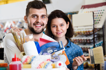 Couple purchasing tools for house improvements in paint supplies store