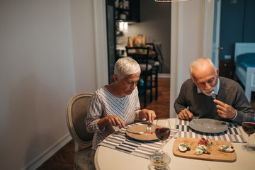 Senior couple eating dinner at home