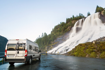 Camping van at beautiful huge waterfall. Amazing cataract at road. Norway. © Drepicter