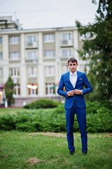 Portrait of a handsome young guy dressed in cool suit posing on the lawn on his prom day. © AS Photo Family