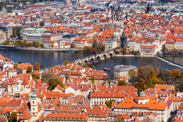 Naklejka na ściany i meble Autumn aerial view of houses and roofs of Prague old city town including Charles bridge. Czech Republic
