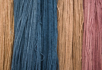 Background: flax fiber hank (birch), different colors (pink, blue, peach), obtained with natural dye, handmade, thanks to vegetables and fruits and the long boiling of the linen fabric, market, Italy